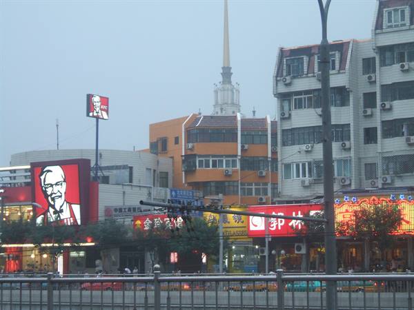 KFC storefront with Colonel Sanders sign among Chinese residential buildings