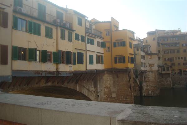 Ponte Vecchio in Florence, colorful houses with green shutters over the Arno