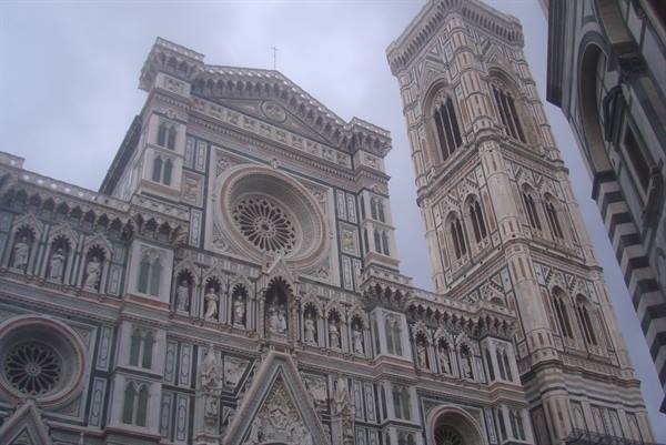 Marble facade of Florence Cathedral with Giotto's bell tower under grey sky