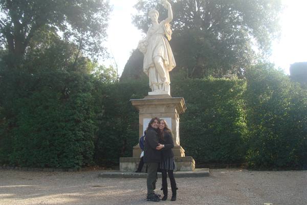 Two girls hugging in front of a marble statue in the Boboli Gardens