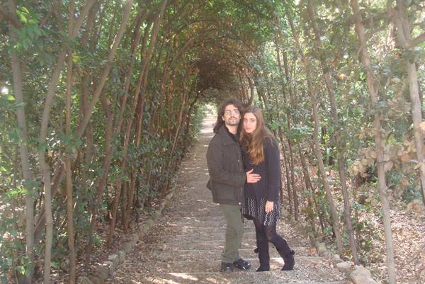 Couple in a green tunnel of intertwined branches, dirt path