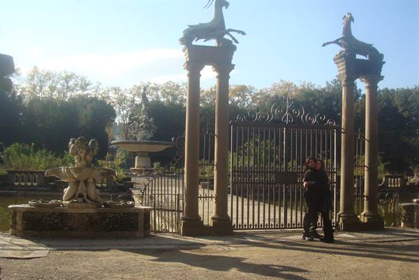 Couple embracing before the wrought-iron gate with goat columns, Boboli Gardens