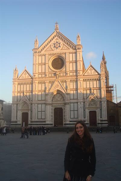 Smiling girl in front of the white facade of Santa Croce, Florence