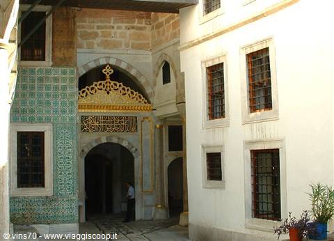 Gilded gate with green tiles and a man standing, Topkapi