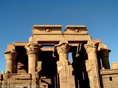 Sandstone papyrus columns of Kom Ombo temple against a blue sky
