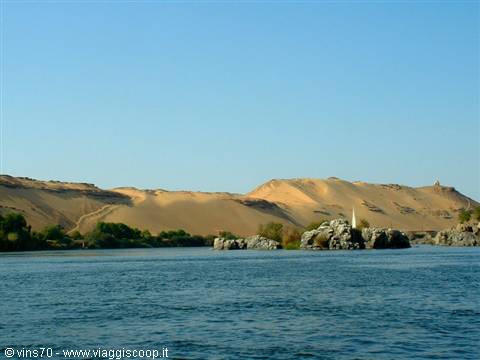 White felucca sail on the Nile at Aswan, rocks and golden dunes