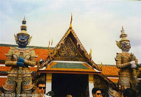 Yak demon statues in front of a golden temple in Bangkok