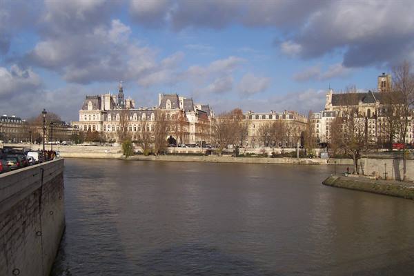 Paris Hôtel de Ville along the Seine, cloudy sky, stone embankment