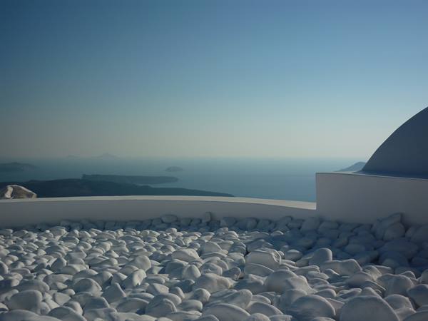 White pebbles terrace with white dome overlooking the Aegean sea, Santorini