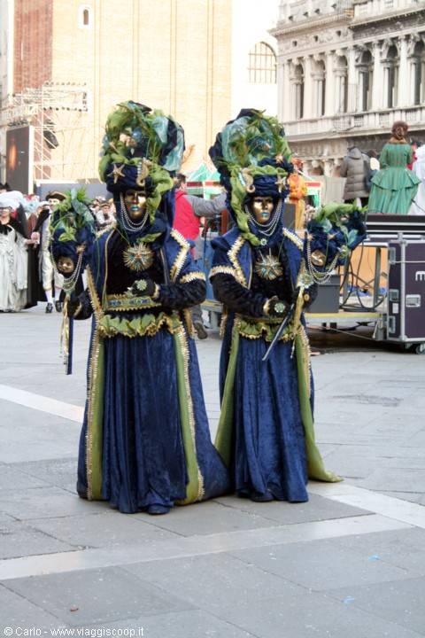Two blue velvet carnival costumes with golden masks in St Mark's Square, Venice