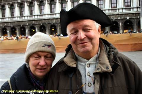 Smiling couple in St Mark's Square, Venice, he wears a Venetian hat