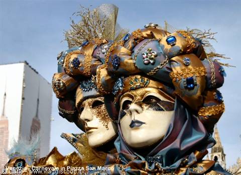 Venice Carnival: masks in golden blue costumes in Piazza San Marco