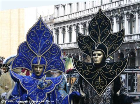 Blue and black carnival costumes with golden faces in St Mark's Square, Venice
