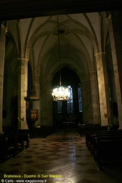 Gothic nave of St. Martin's Cathedral in Bratislava, lit chandelier among stone pillars