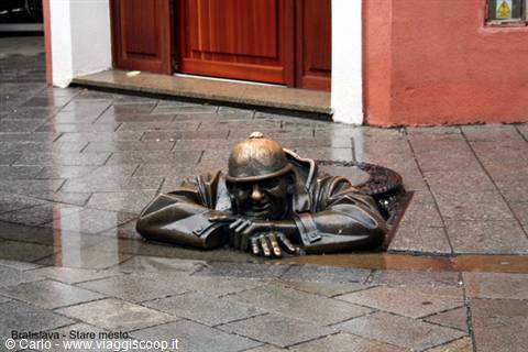Bronze statue of a man peeking from a manhole, Bratislava
