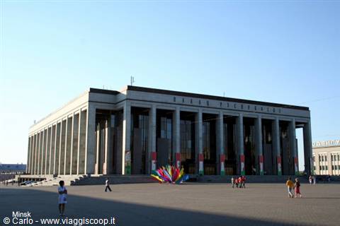 Opera Theatre in Minsk, stone colonnade under blue sky, people crossing the square