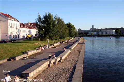 Stone embankment along the Svislach river in Minsk, people sitting on steps