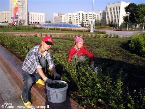 Two girls wearing gloves planting shrubs in a Minsk square