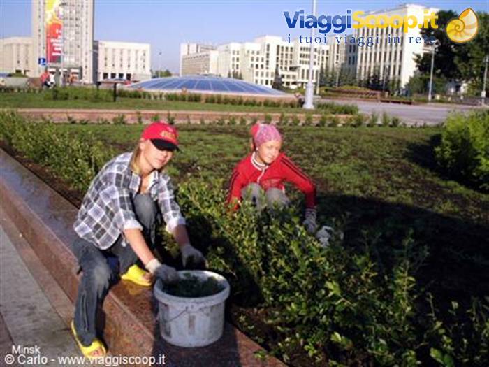 Two girls wearing gloves planting shrubs in a Minsk square