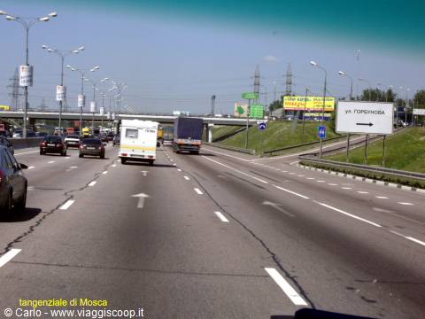 Moscow MKAD ring road with trucks and cars under a clear blue sky
