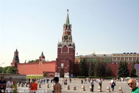 Tourists walk on Red Square in front of the Kremlin Spasskaya Tower