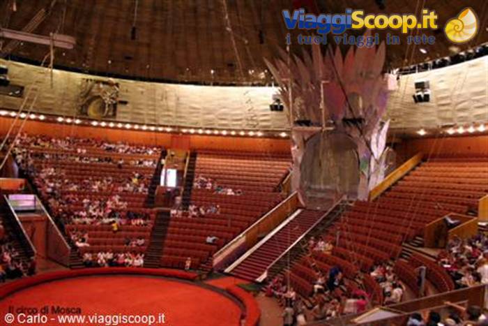 Red arena inside the Moscow Circus with wooden stands and scattered audience