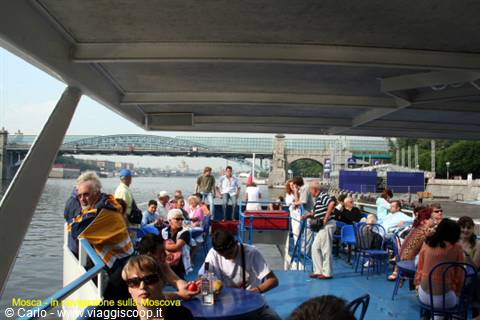 Tourists cruising on the Moskva River under a bridge in Moscow