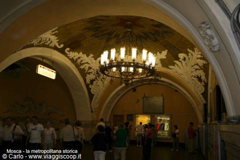 Historic Moscow metro: chandelier under a vault decorated with golden frescoes