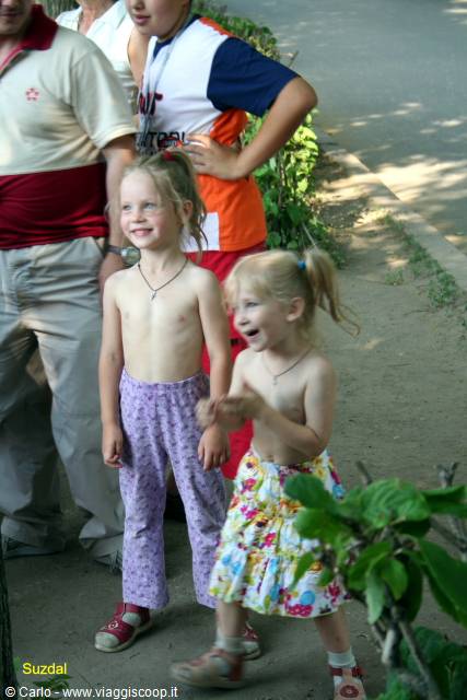 Smiling children in summer clothes in Suzdal, among greenery and shade