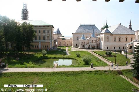 Rostov Kremlin: white buildings with tent roofs, small pond and visitors on the lawn