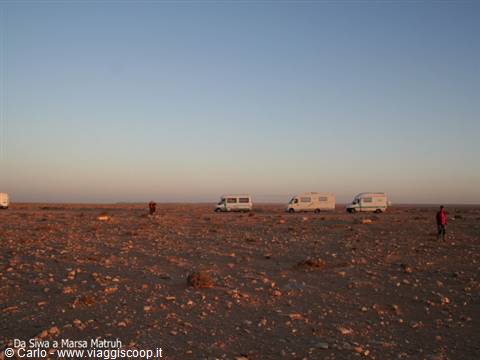 Camper vans lined up across the stony desert between Siwa and Marsa Matruh