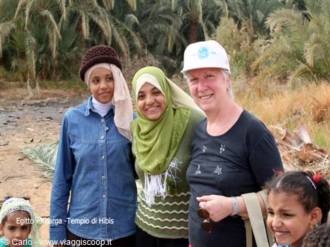Tourist with two Egyptian women with henna hands among palm trees, Siwa