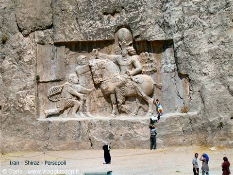 Visitors stand before the Sasanian rock relief at Naqsh-e Rostam, near Persepolis
