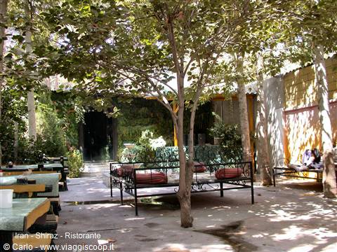 Restaurant courtyard in Shiraz with iron daybeds under shady trees