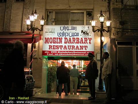 Lit sign of Moein Darbari Restaurant in Mashhad, people at entrance