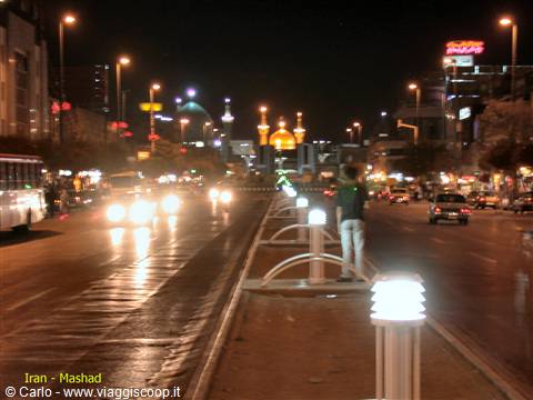 Mashhad avenue at night, golden shrine in the distance, traffic and streetlights