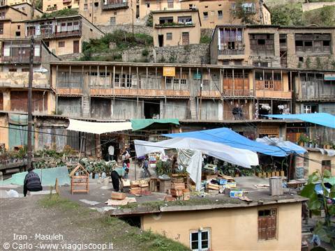 Masuleh: market stalls under blue tarps, wooden houses on the hillside