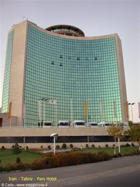 Pars Hotel in Tabriz: curved tower with green glass facade at dusk