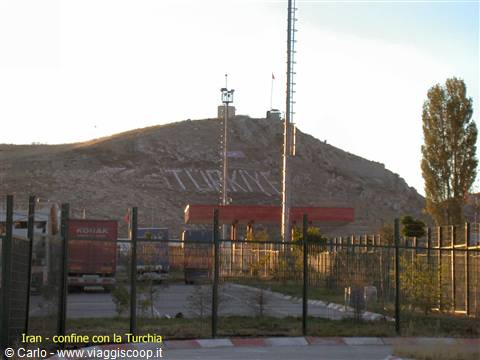 Border crossing to Turkey written on the hill, trucks at the gates