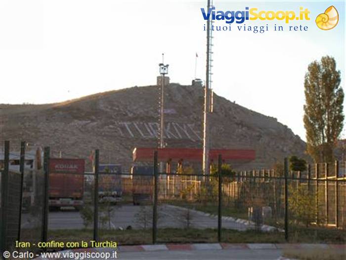 Border crossing to Turkey written on the hill, trucks at the gates