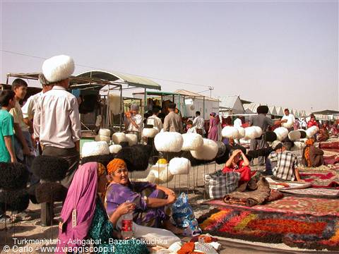 Tolkuchka bazaar: sellers with felt hats and carpets under the sun