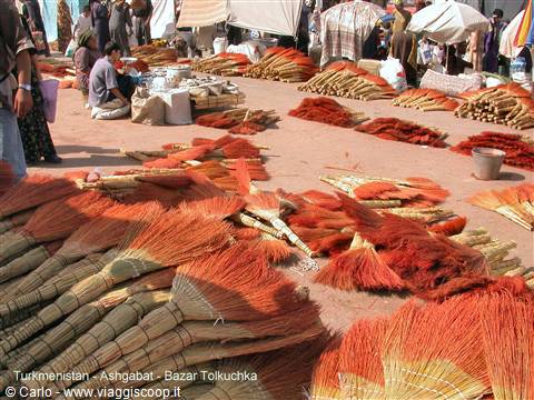 Ashgabat market: red sorghum brooms for sale, vendors and white tents