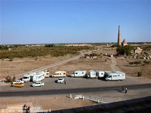 Campervans parked on arid ground near the Kutlug Timur minaret, Kunya-Urgench
