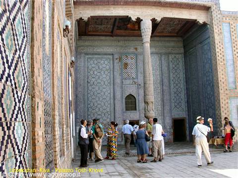 Tourists in the courtyard of Tosh-Khovli palace in Khiva, blue tiles