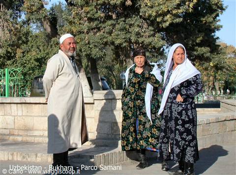 Bukhara, Samani Park: elderly people in traditional robes in sunlight