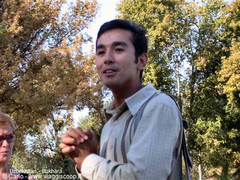Smiling young guide in Bukhara, autumn trees and morning light