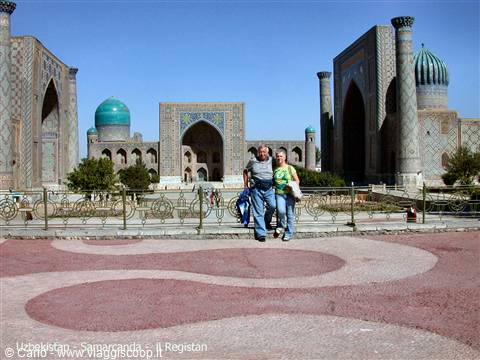 Tourists in front of Samarkand's Registan, tiled madrasas with turquoise domes under blue sky