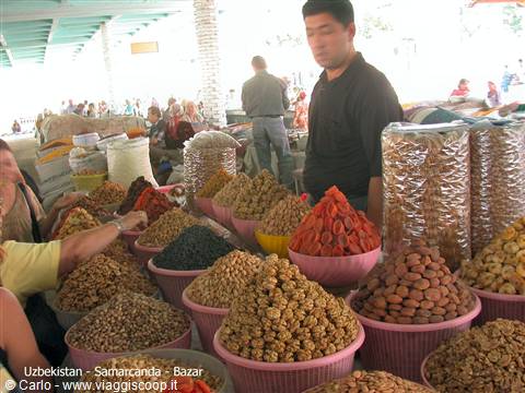 Samarkand bazaar: vendor among bowls of dried fruit and nuts