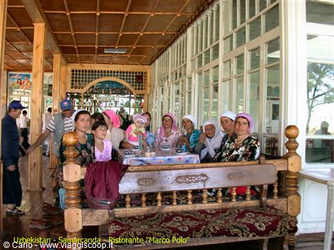 Women in headscarves seated on a carved wooden sofa at Samarkand's Marco Polo restaurant