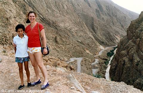 Tourist and girl beside the winding road down the rocky Dades gorge